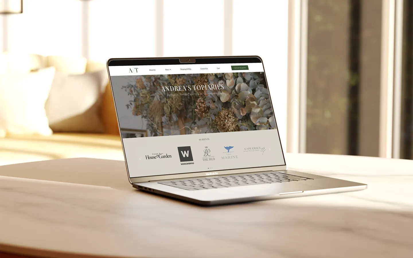 The Andrea's Topiaries website on a laptop