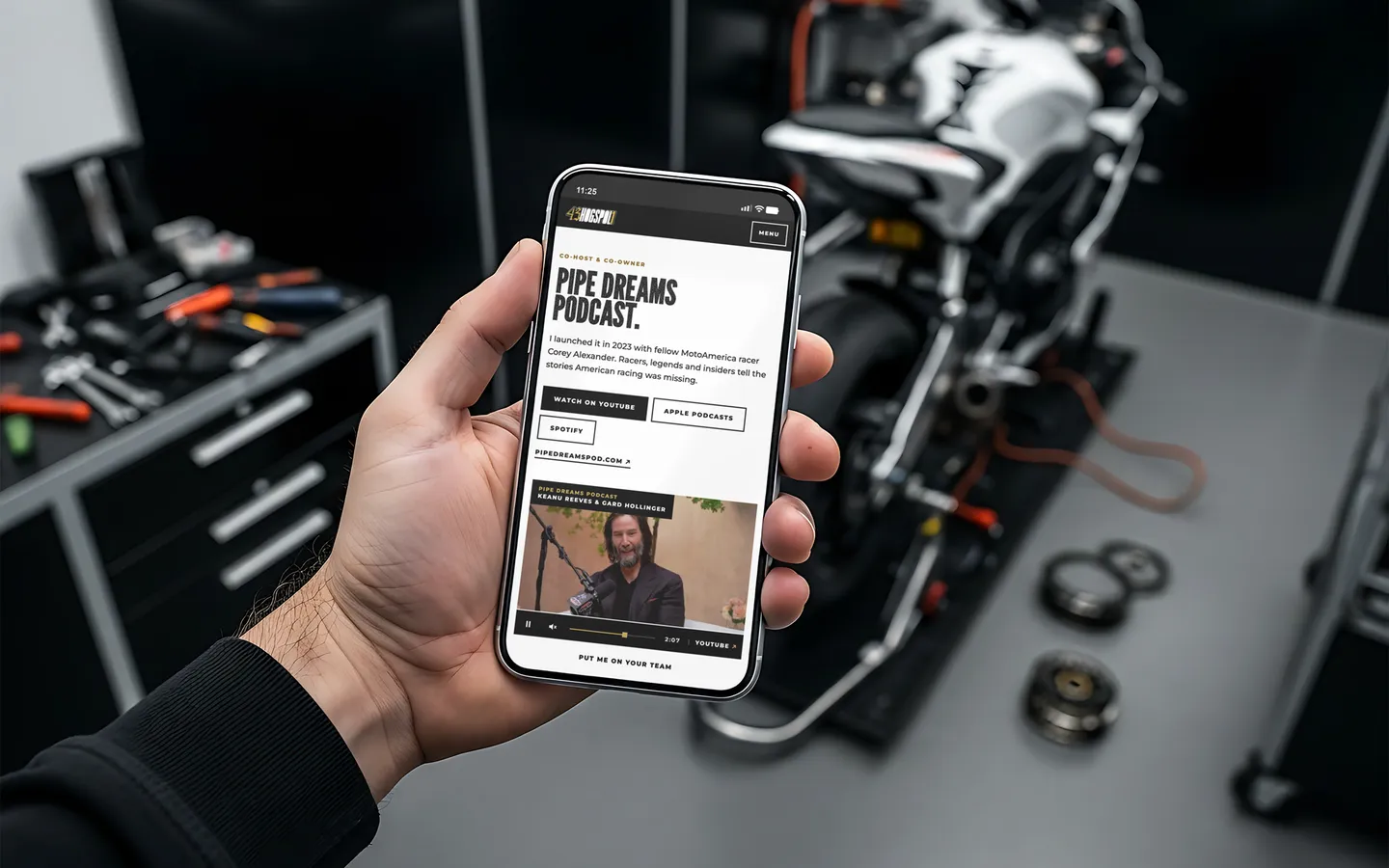 James Rispoli's site on a phone, held in a workshop: the Pipe Dreams Podcast