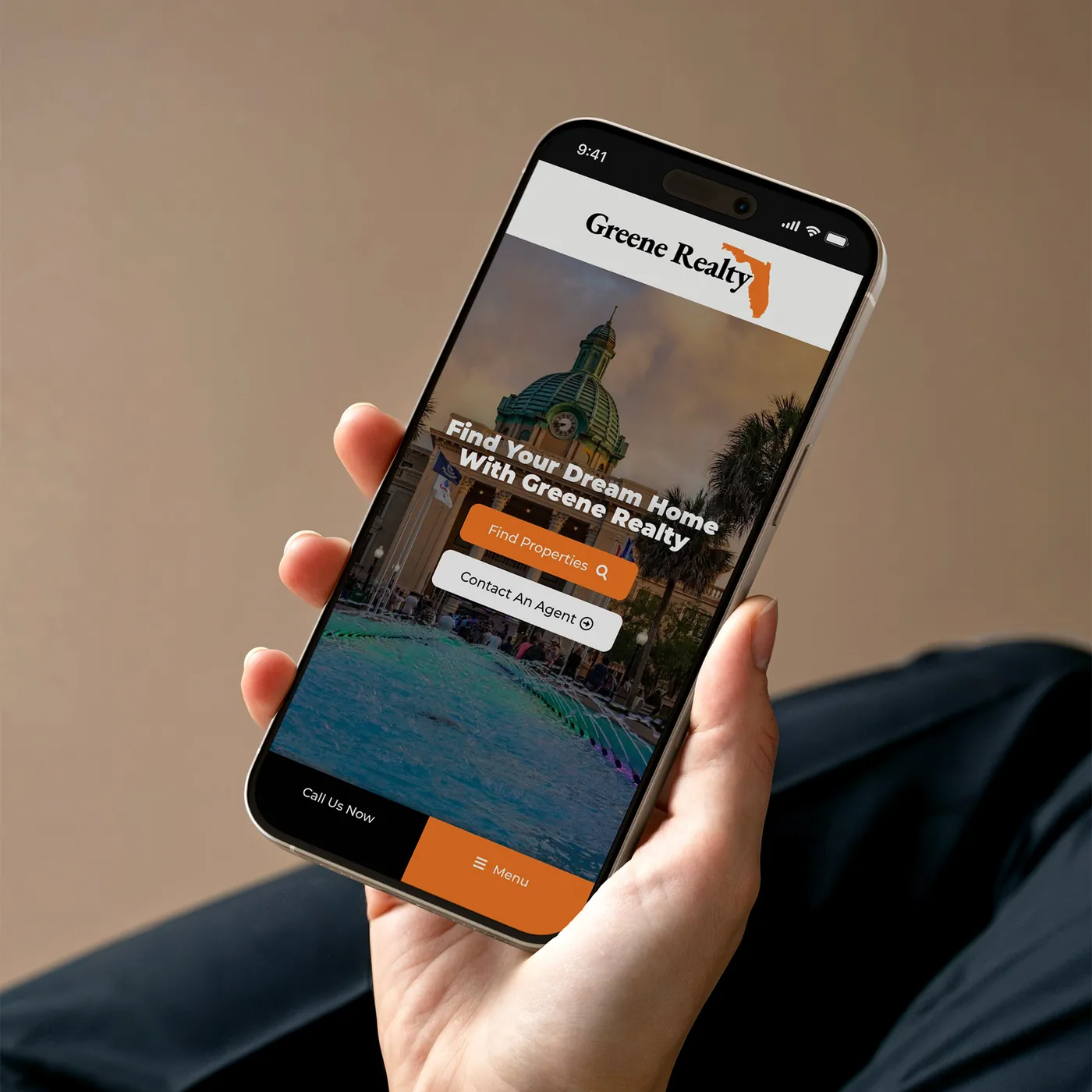 Greene Realty's homepage on a phone in a hand: Find Your Dream Home, with Find Properties and Contact An Agent