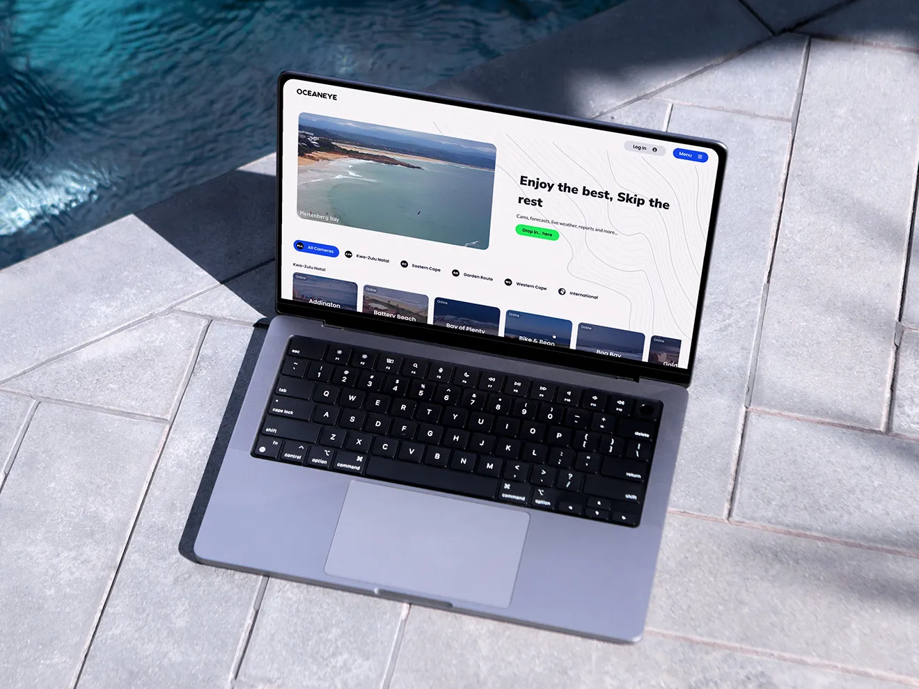 OceanEye's homepage on a laptop by a pool: the cameras, sorted by coast