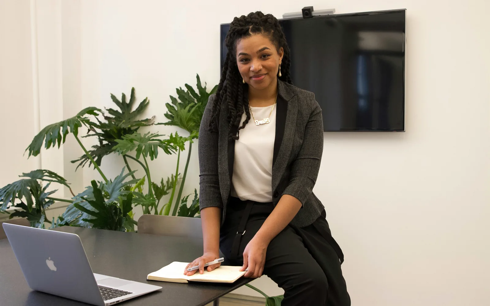 A young founder at her desk with a laptop and a notebook: licensed stock, as used in the registration ads